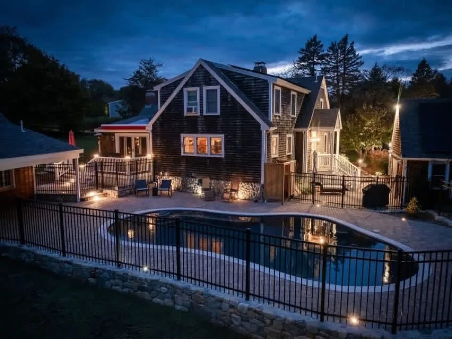 South Shore pool patio and outdoor living installation lit at twilight