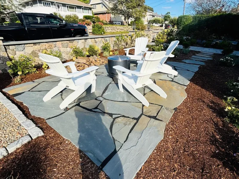 Natural stone wall and flagstone patio with fire pit built by C.J. McCarthy